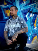 Man wearing a graphic t-shirt in front of a colorful mural.